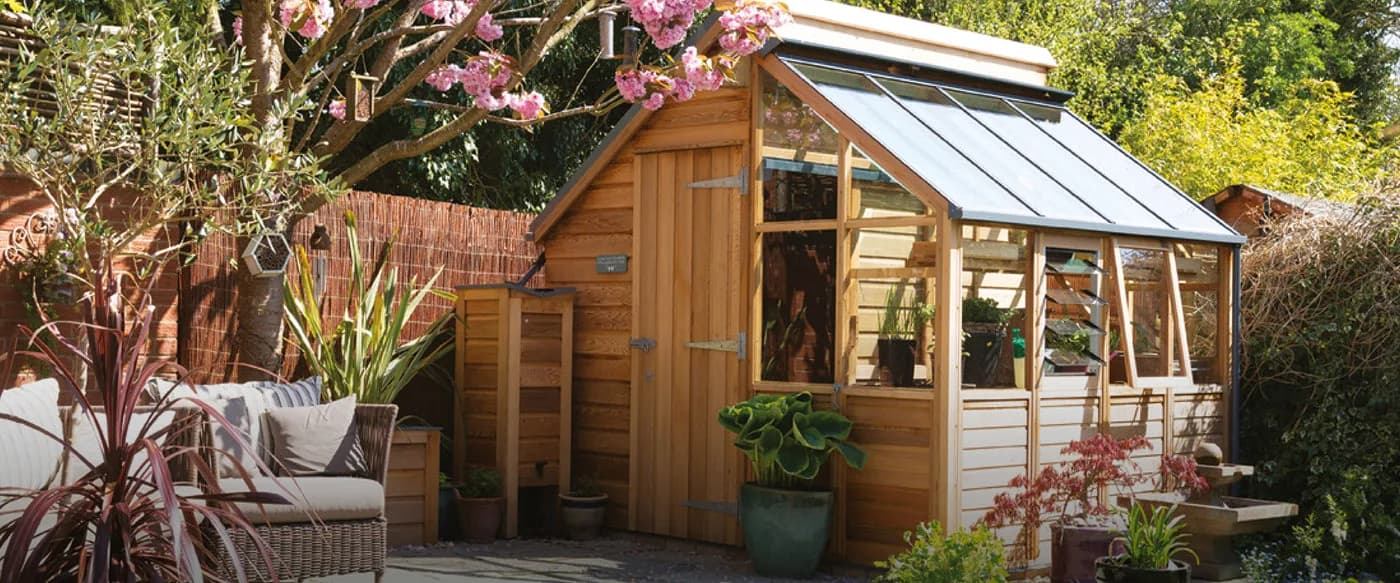 Gabriel Ash Classic Grow and Store combination cedar greenhouse and shed on a sunny patio