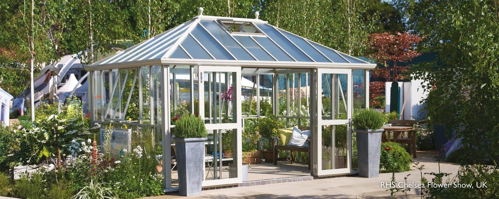 Hartley Botanic Westminster glasshouse in a pale finish with a hipped roof at the RHS Chelsea Flower Show