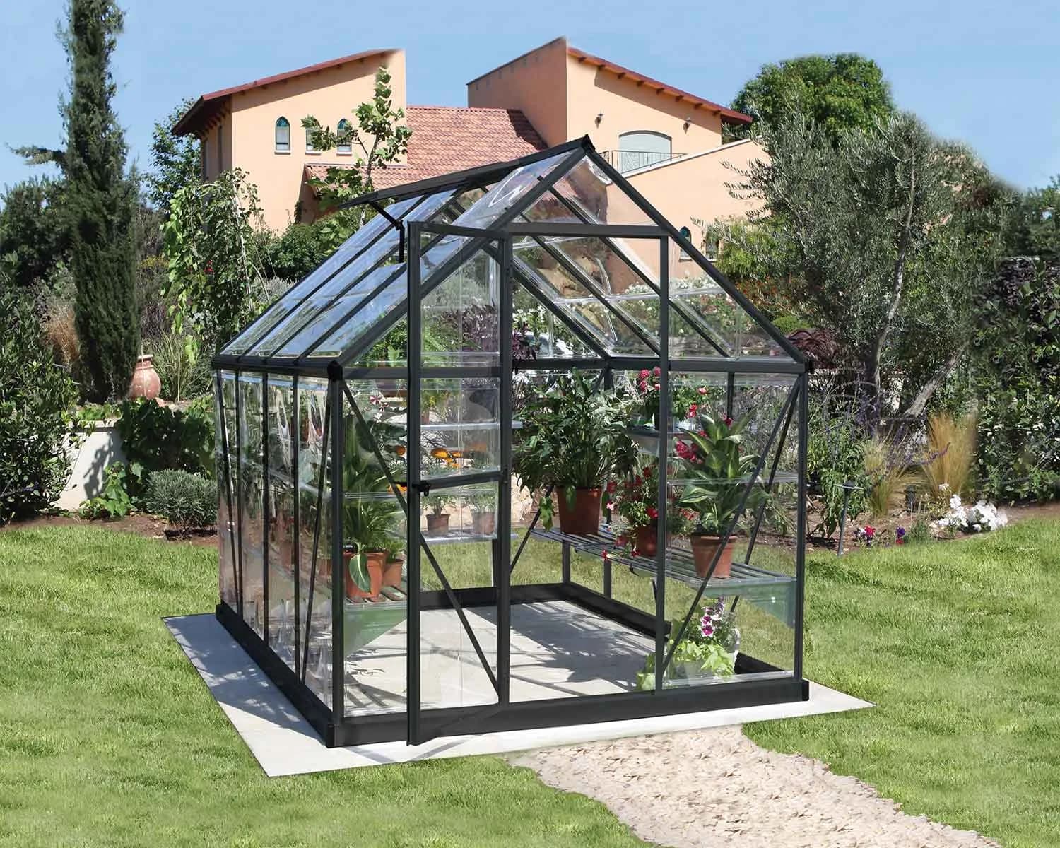 Canopia Harmony 6x8 greenhouse with clear polycarbonate panels installed in a backyard garden